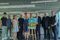 des hommes et femmes posent pour la photo autour de l'affiche du Tour de France 2026